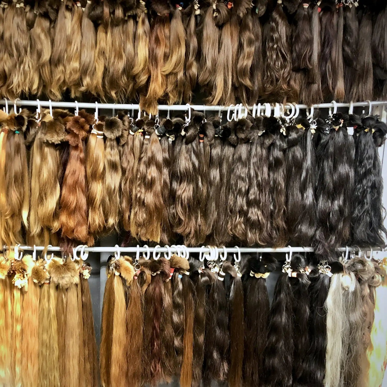 Päckchen mit Haarverlängerungen in verschiedenen Längen, Texturen und natürlichen Farben.